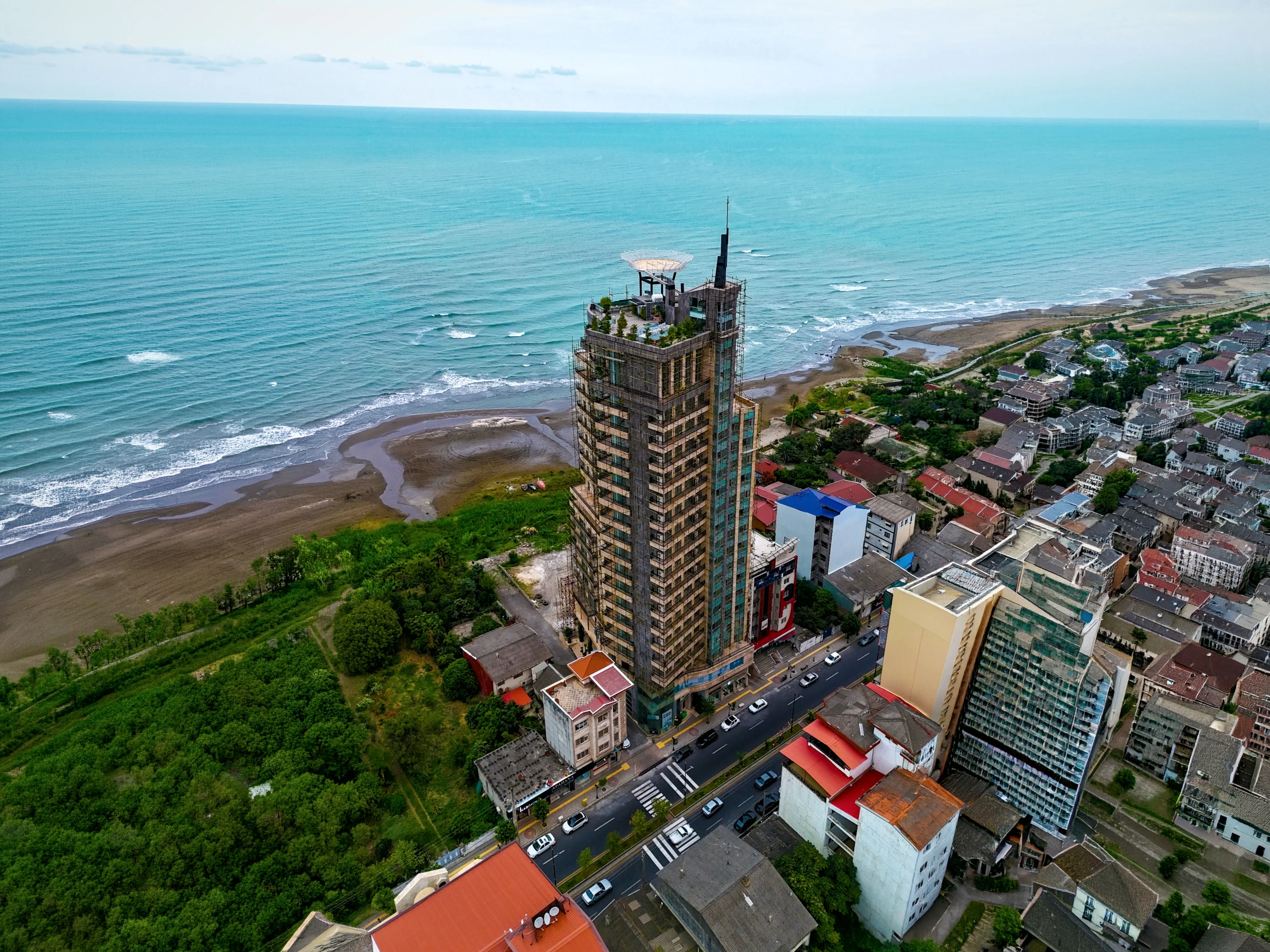 Maghrebi Tower from the air, standing on the shoreline with open sea behind it