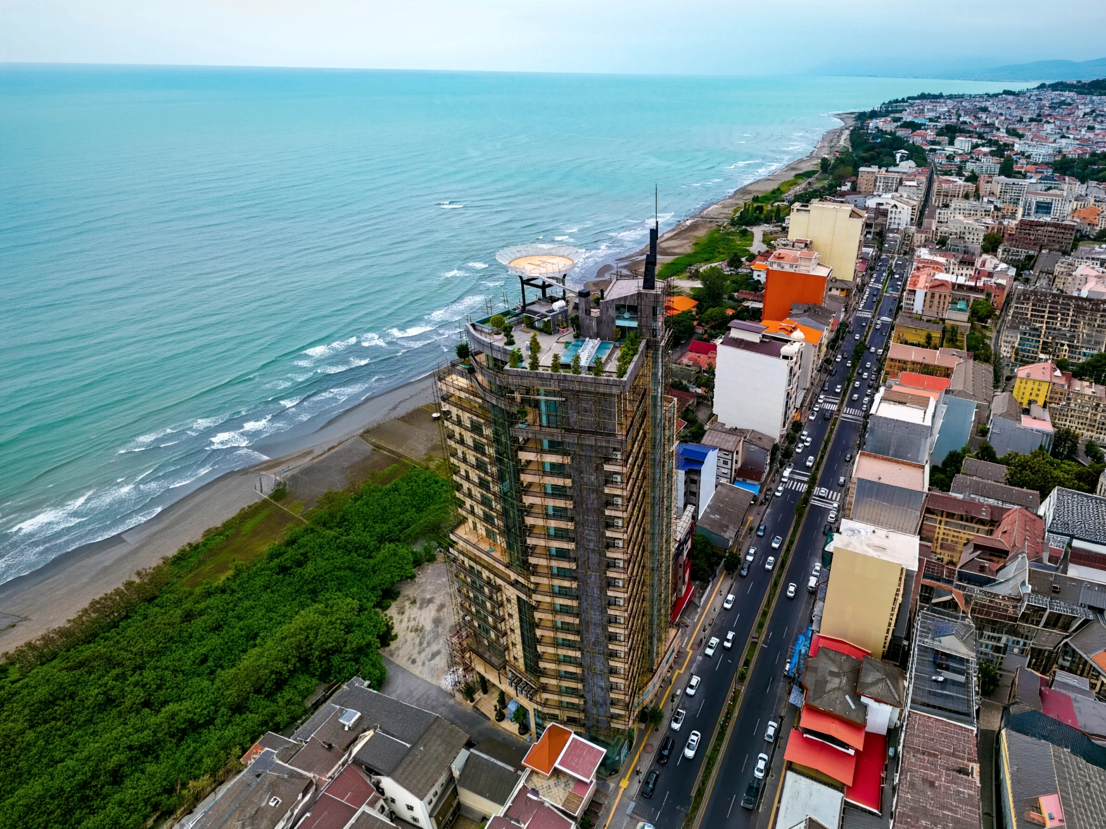 The tower seen along the coastline, the town stretching away to the east