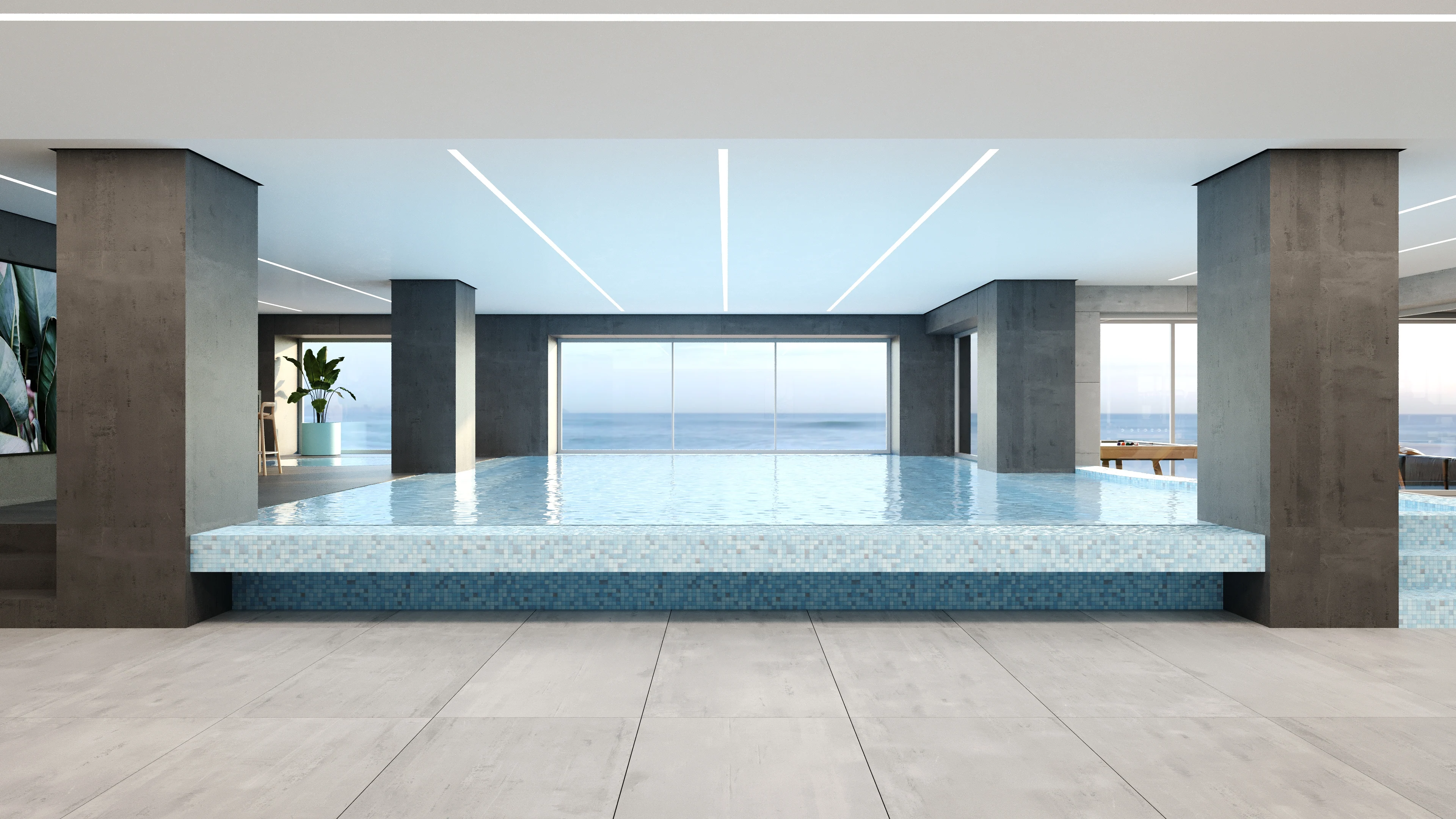 Indoor pool behind full-height glazing, facing the sea